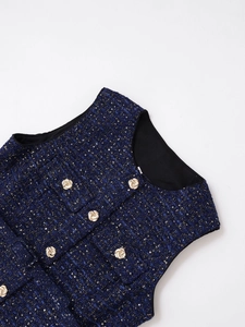 Detail der dunkelblauen Tweed-Weste mit goldenen Reliefknöpfen und Pailletten