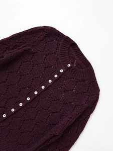 Close-up of deep purple knit cardigan with crochet pattern and white buttons detail