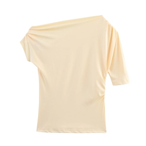 Détail d'un haut beige à épaule dénudée avec encolure plissée et tissu fluide satiné