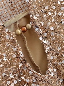 Detail of bohemian sequined mesh fabric with triple bead closure on spring dress