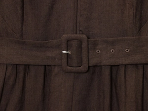 Détail de la taille d'une robe en lin avec boucle de ceinture carrée gainée et texture marron foncé