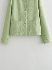 Detail of light green tweed jacket with silver buttons and textured fabric weave