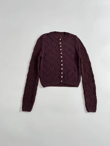 Detail of purple pointelle knit cardigan featuring delicate mesh cutouts and white buttons