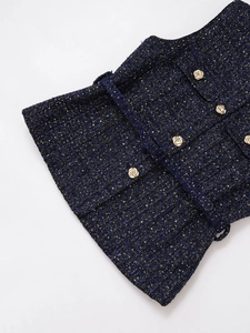 Detailansicht von marineblauem Tweed-Stoff mit Goldfäden und dekorativen geprägten Goldknöpfen