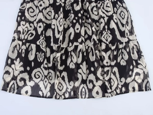 Detailed view of layered bohemian chiffon skirt with black and white abstract floral print