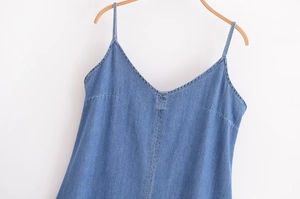 Détail de la robe en jean bleu clair avec col en V et doubles coutures orange