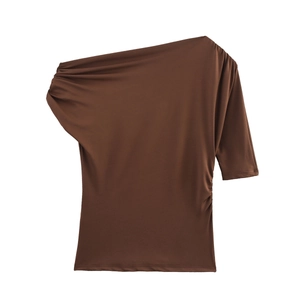 Détail du haut marron asymétrique à une épaule avec des plis élégants sur le côté