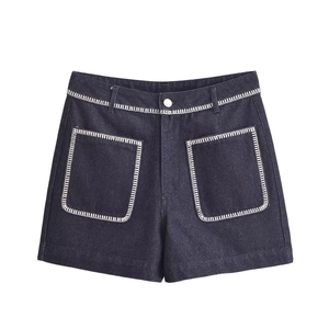 Detail of dark blue high-waisted denim shorts featuring contrast white topstitching and pockets