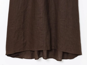 Détail de l'ourlet arrondi asymétrique d'une robe trapèze sans manches en lin marron