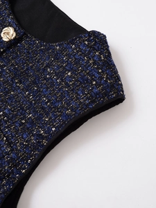 Detailansicht der blauen Tweed-Stoffstruktur mit goldenen Knöpfen auf der Weste