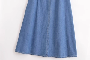 Vue détaillée d'une robe en jean bleue avec doubles surpiqûres jaunes et texture de qualité