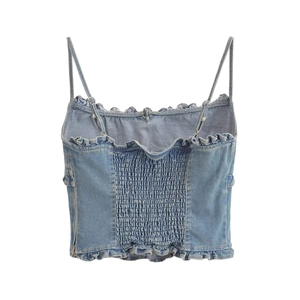 Dettaglio del retro elasticizzato e top in denim con volant e spalline regolabili in blu