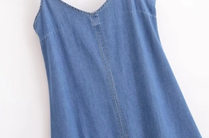 Gros plan d'une robe en jean à col en V montrant la couture et la texture du tissu