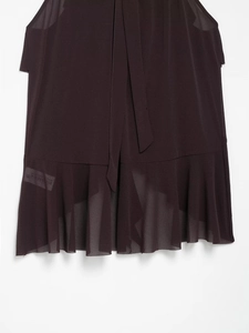 Detail of elegant dark brown chiffon top featuring neck ties and delicate ruffled hemline