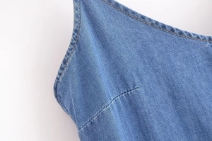 Gros plan détaillé du décolleté de la robe en jean bleu avec surpiqûres précises