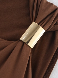 Vue détaillée du tissu froncé marron foncé avec une boucle métallique dorée chic