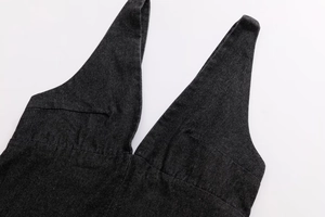 Detailed view of deep V-neckline and twill fabric texture on a dark denim dress