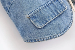 Détail de l'ourlet en denim bleu clair avec surpiqûres contrastées et cordon tressé