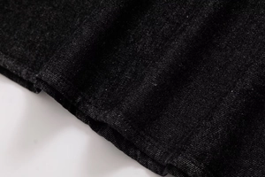 Close-up of premium black denim fabric showing high-density twill weave and texture