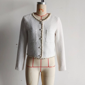 Détails de la veste en tweed blanc avec boutons perlés et finitions en perles fines