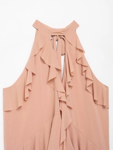 Detail of apricot halter neck top showing elegant layered ruffles and back tie bow