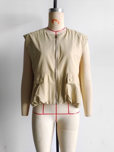 Close-up of khaki sleeveless vest with front zipper and large utility flap pockets