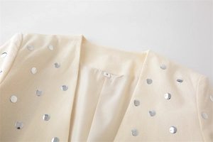 Detailansicht des beigen Blazers mit silbernen Nieten und weichem Innenfutter