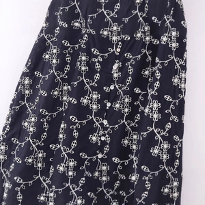 Women's vintage black midi dress featuring white floral embroidery and button front closure