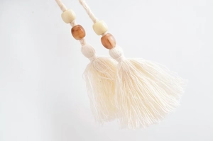 Détail du gland en coton crème avec des perles en marbre et des franges de style bohème