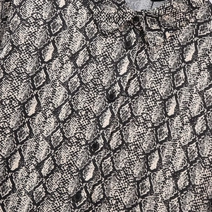 Nahaufnahme der Damen Herbst Schlangenprint Satinbluse mit Reverskragen und schwarzen Knöpfen