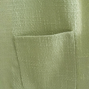 Close-up of sage green tweed casual jacket featuring a textured square patch pocket detail