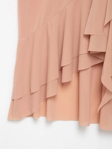 Detail shot of pink layered ruffles and asymmetric hemline on a chic halter top