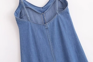 Détail du dos d'une robe en jean bleue avec fines bretelles réglables et coupe en V