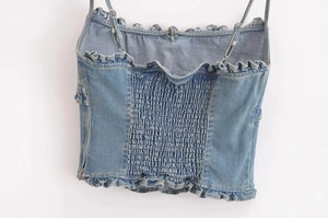 Dettaglio retro del top in denim con elastico a punto smock e rifiniture a volant