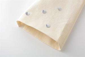 Detail eines cremefarbenen Blazers mit silbernen Nieten und Leinen-Webstruktur