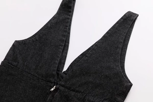 Detailed close-up of a dark grey denim V-neck top with a silver metal front zipper
