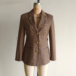 Dettaglio del blazer marrone pied-de-poule con classici bottoni in metallo dorato