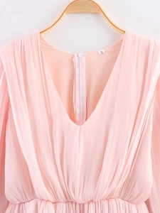 Detail of pink V-neck dress featuring ruffled collar and pleated texture with a size S label