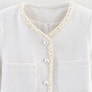 Veste en tweed blanc avec bordure en perles et boutons nacrés au style chic américain