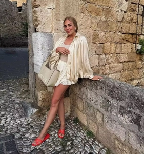 Outdoor-Streetstyle mit beigem Oversize-Hemd und weißem Spitzenrock mit Accessoires