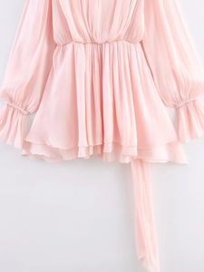 Detail of light pink chiffon tiered ruffles and pleated textures on a flowing summer dress