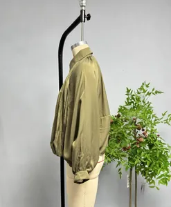 Detail of loose olive green satin jacket featuring puffy lantern sleeves and classic collar