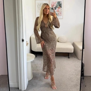 Sparkly champagne gold sequin maxi dress with a deep V-neck and stylish metal ring detail