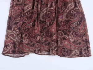 Detail of bohemian paisley print hem on lightweight chiffon dress with refined stitching