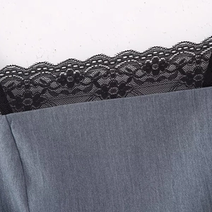 Détail de la robe à fines rayures bleu-gris avec broderie florale en dentelle noire délicate