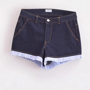 High-waisted dark blue denim shorts with light blue striped ruffle hem patchwork design
