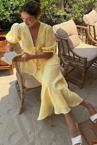 Détail d'un ensemble jaune haut à manches bouffantes et jupe midi pour look de vacances