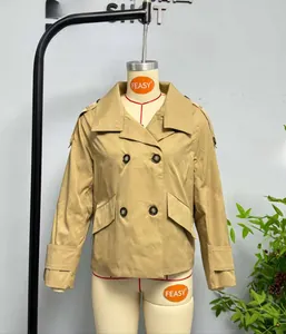 Detail shot of khaki double-breasted trench coat featuring classic lapels and cuff straps