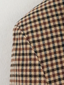 Dettaglio della cucitura della spalla di un blazer in tweed con motivo pied-de-poule