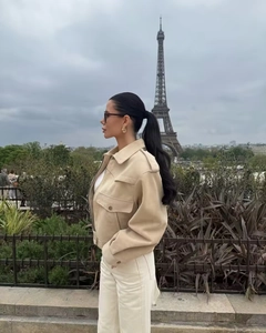 Close-up of a beige faux suede utility jacket featuring large pockets and shoulder epaulettes
